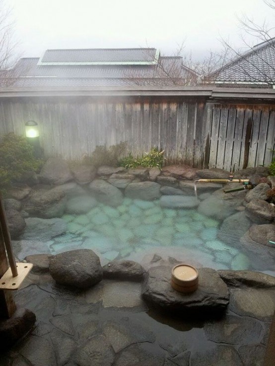 an outdoor hot tub designed with natural stones and rocks - even if there's no hot spring, you can make such a tub yourself