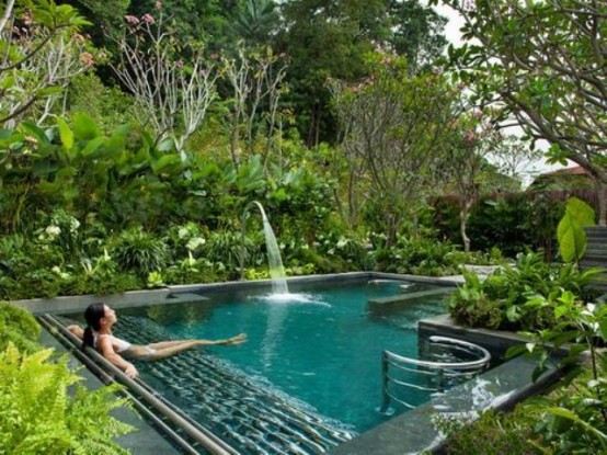 a small outdoor pool with a waterfall and greenery growing around create your personal oasis for relaxation