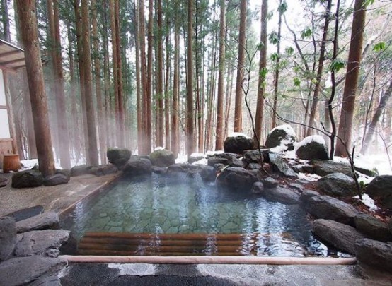 a hot bathtub outdoors designed with rocks and stones will keep you super relaxed, especially during cold seasons