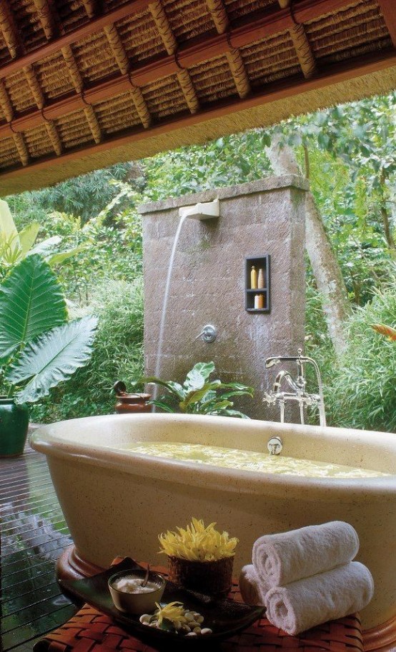 an outdoor waterfall shower and a stone bathtub next to it - you can choose your experience each time you want