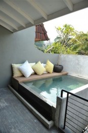 a plunge pool with a tiny deck and pillows on it will fit even the smallest outdoor space