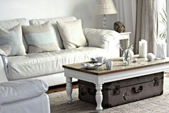 a low shabby chic coffee table with a suitcase under it for storing some things you need