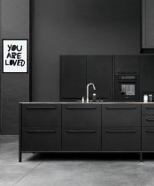 a matte black kitchen with sleek metal cabinets and a kitchen island, matte graphite grey walls and an artwork