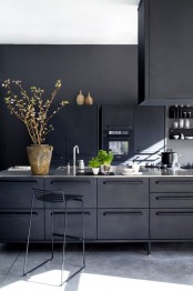 a refined minimalist matte black kitchen of metal, with a large kitchen island, a hood, white countertops and black stools