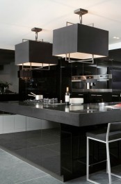 a minimalist black kitchen with glossy surfaces, built-in appliances, black pendant lamps and black stools
