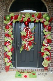 a garland of green and red mesh to cover the door line and a decoration with ribbons and a candy cane on the door