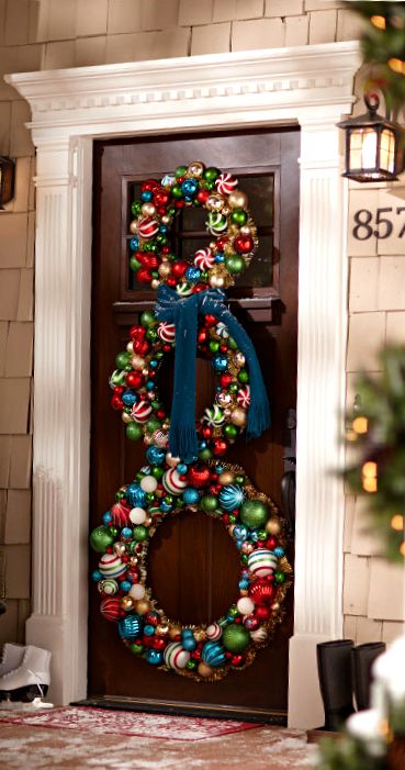a colorful snowman of bright Christmas ornaments and a teal scarf is a stylish bright decoration for holidays