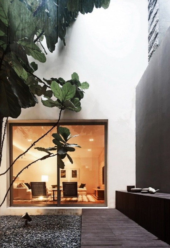 an indoor courtyard with pebbles and some trees growing right here is a cool and fresh idea
