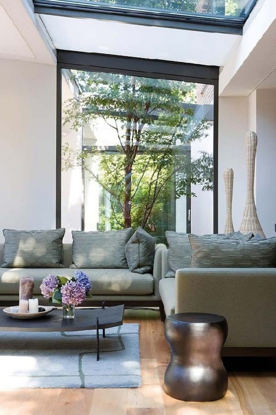an indoor courtyard with a couple of trees growing here is a very good idea for a contemporary space to enliven it