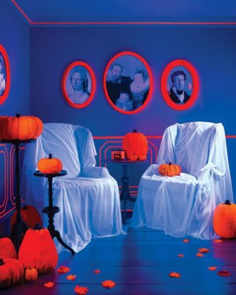 neon orange pumpkins and portraits in neon orange frames accent the space and make it Halloween-like instantly
