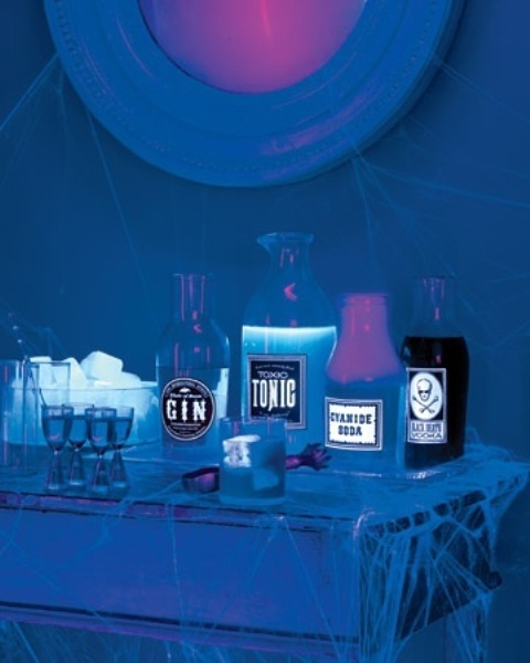 a neon blue drink table glowing in the dark plus pink neon lights is a cool and fresh idea for a fun Halloween party