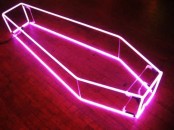 a neon pink coffin light is a fresh and modern idea to decorate your space for a Halloween party