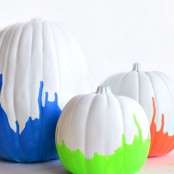 white pumpkins spruced up with neon green, blue and orange touches are a very fresh and bold idea for Halloween decorating
