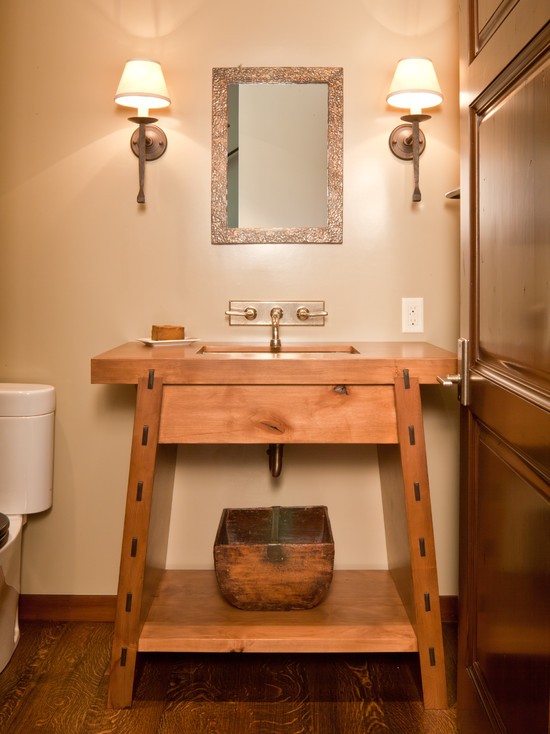 a simple stained wooden vanity with a built-in sink is a stylish idea for a rustic bathroom