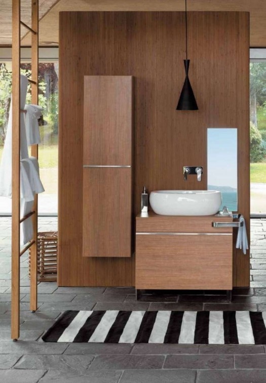 a contemporary bathroom with sleek wooden furniture for storage, a modern bowl sink, a black pendant lamp and a ladder plus a striped rug