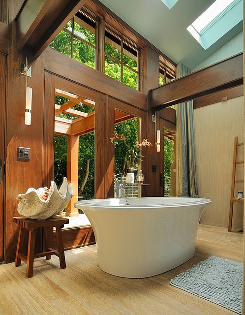 a modern bathroom with a light stained wall and a laminate floor, a rich stained wall and matching beams is a very elegant space with much natural light