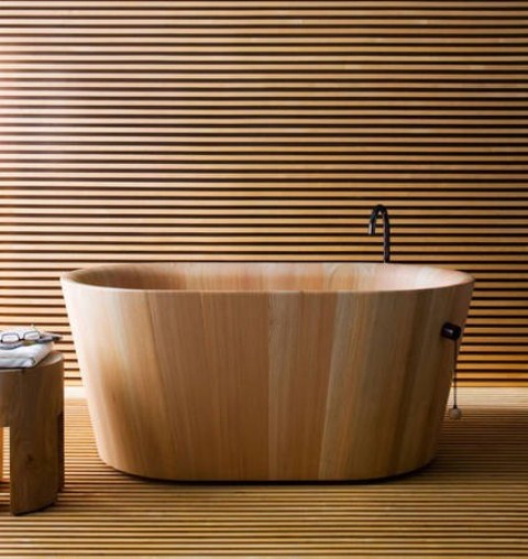 a neutral minimalist bathroom fully clad with light-stained wooden slabs, a wooden bathtub and a matching stool is very zen-like