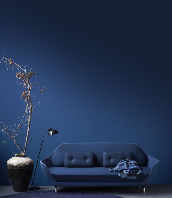 a beautiful midnight blue sofa with a sleek shape and matching upholstery, with metal legs is a stylish and bold idea for a modern space