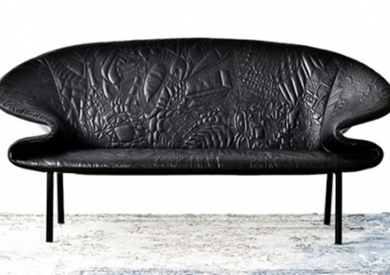 a black loveseat with a very catchy shape and black embossed leather is a bold statement with shape and pattern