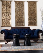 a beautifully and uniquely shaped dark-stained sofa with navy upholstery is a stylish and exquisite solution