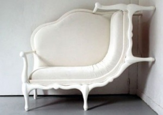 a creative creamy sofa with a classic vintage design climbing up the wall is a gorgeous statement with a touch of whimsy