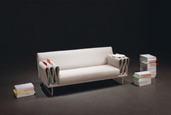a creamy sofa with creative armrests that are folded and show off storage for books, magazines and other small things