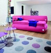 a hot pink sofa with bold blue pillows, with large buttons and an eye-catchy shape is a lovely and cozy idea to make a statement