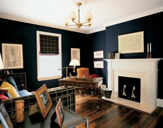 a stylish masculine home office with navy walls, a fireplace, a plaid sofa and curtain, a refined wooden desk