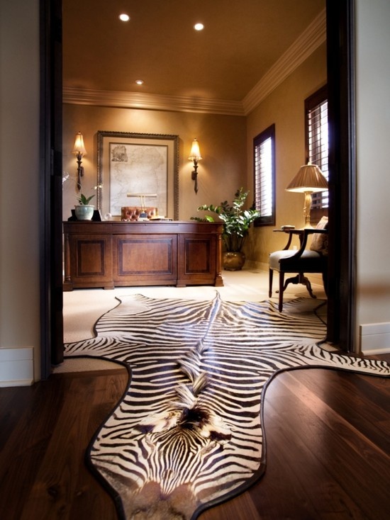 a luxurious home office with neutral walls, a refined desk, a faux animal skin and elegant lamps
