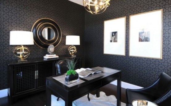 a moody art deco home office with printed wallpaper, black furniture, sphere lamps and a black and gold mirror