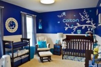a bold blue and white boy’s nursery with paneling on the walls, dark stained furniture, printed and bold textiles is a stylish idea