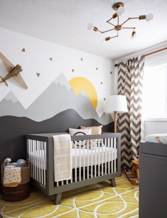 a grey and yellow nursery with a wall mural and a plane on the wall, a grey crib with neutral bedding, a bold yellow rug and printed curtains is amazing