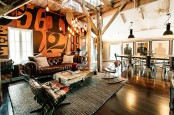 a leather sofa, an industrial coffee table of wood on wheels, lots of pendant bulbs and vintage metal chairs