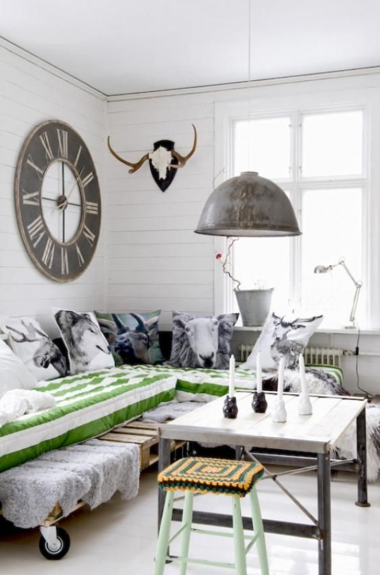 a pallet daybed on casters, a pendant metal lamp, a wood and aged metal coffee table for an industrial feel
