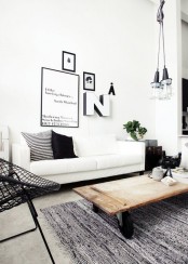 a wooden coffee table on wheels and industrial pendant lamps in a cluster create an industrial ambience