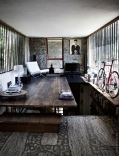 an aged wood floor, stone walls and a concrete ceiling make up a cool rough base for an industrial living room
