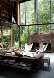 a leather sofa, a stone clad fireplace add an industrial feel to the layout