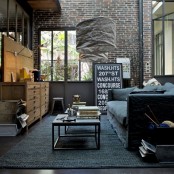 brick walls and a dark concrete floor make up a cool backdrop to fill in, and some industrial furniture adds to it