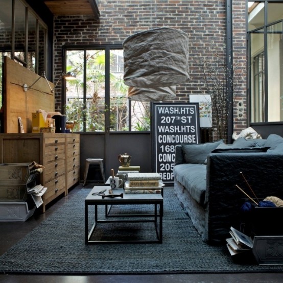 brick walls and a dark concrete floor make up a cool backdrop to fill in, and some industrial furniture adds to it