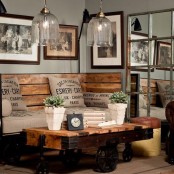 a sofa with a back and sides of stained wood on casters and a matching coffee table plus glass pendant lamps