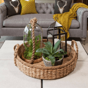 a basket tray with a terrarium, a candle lantern and a potted plant for a boho chic feel