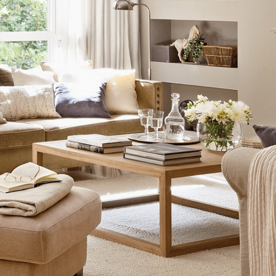 fresh white blooms in a clear vase, books and a tray with glasses and a carafe