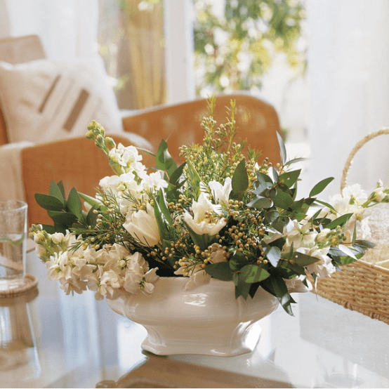 a vintage white porcelain bowl with fresh white blooms and greenery for decorating a coffee table