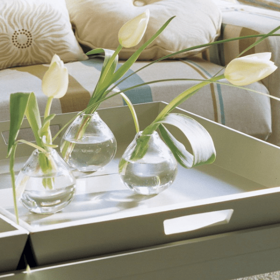 a white tray with clear vases and white tulips for contemporary chic as it is