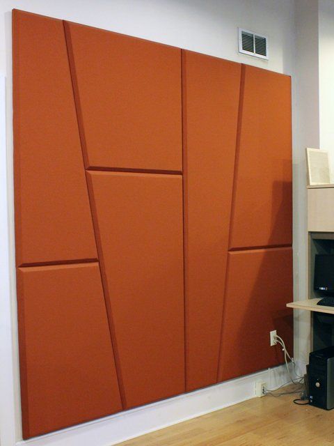 a soundproofing wall done with asummetrical rust colored wall panels