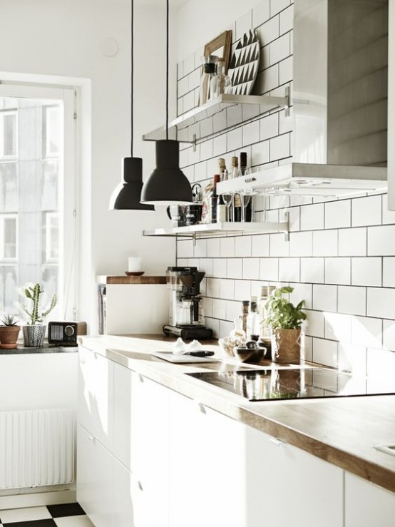a white Scandinavian meets mid-century modern kitchen with sleke cabinets, butcher block, white subway tiles 