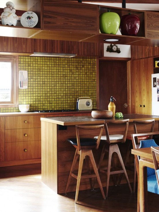 a bold mid-century modern kitchen with rich-stained cabinets, a yellow tile backsplash and upper cabinets over the kitchen island