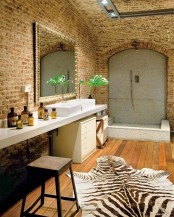 a bold and whimsy bathroom with brick walls, a long vanity with a sink and a mirror, a shower space done with stone and a faux animal skin