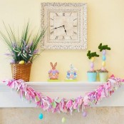 a colorful bunting, colorful faux eggs and moss bunnies and blooms and grass in pots