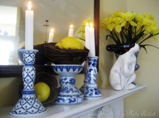 a bright Easter mantel with a floral arrangement, a nest with lemons and blue candle holders